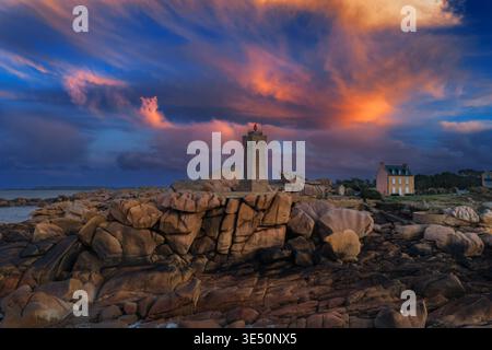 Veduta aerea del faro di Ploumanaca'h in piedi su rocce di granito rosa sotto un suggestivo cielo al tramonto a Perros-Guirec, Bretagna, Francia. Foto Stock