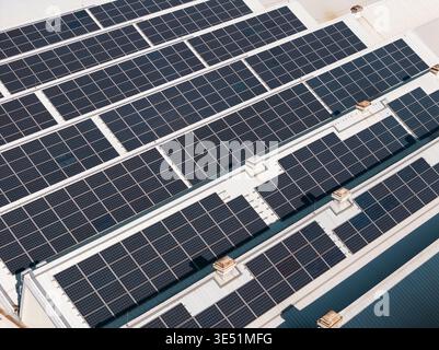 Vista aerea dei pannelli solari sui tetti che mostrano la produzione di energia pulita per pratiche sostenibili. Foto Stock