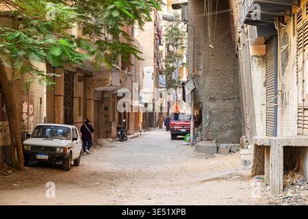 Una strada secondaria stretta e non asfaltata con case e negozi nella città vecchia del Cairo, in Egitto. Foto Stock