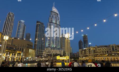 Vista panoramica notturna dello spettacolo della fontana di Dubai con il Burj Khalifa illuminato e lo skyline del centro di Dubai che si riflette nel lago, Emirati Arabi Uniti Foto Stock