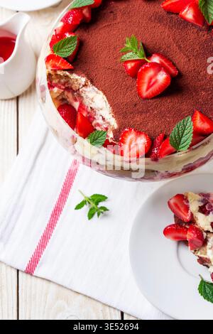 Dessert trifle alla fragola con strati di crema e menta in ciotola di vetro Foto Stock