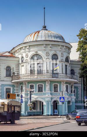 Un bellissimo edificio storico con uno stile architettonico unico e una bandiera Ucraina in mostra sotto un cielo blu luminoso in una giornata di sole Foto Stock