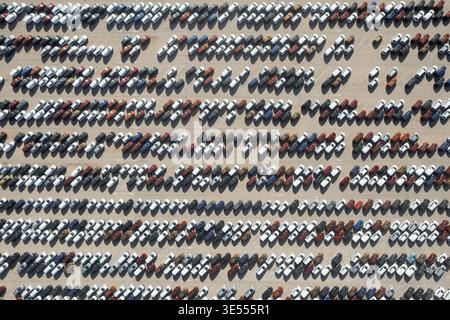 Vista aerea di centinaia di nuove auto parcheggiate in file organizzate presso un grande terminal logistico a Malaga, Andalusia, Spagna. Foto Stock