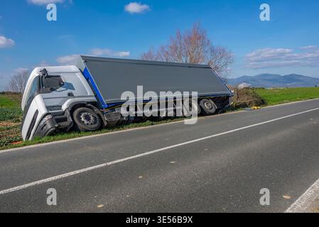Un carrello si piega su un lato dopo essere uscito dalla strada Foto Stock