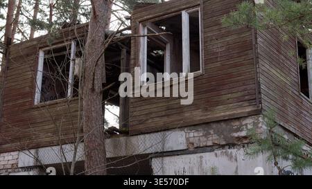 Edificio in legno abbandonato nella foresta - casa abbandonata con finestre rotte Urbex Photography Foto Stock