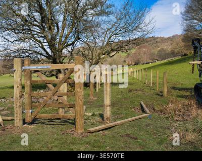 Derbyshire, UK - 26 mar 2026: Costruzione di un nuovo sentiero nella campagna aperta vicino a Hathersage Derbyshire UK con una recinzione a pali in legno e luce primaverile sotto un cielo azzurro Foto Stock