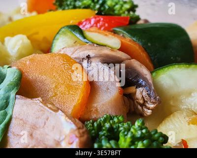 Foto ravvicinata di verdure miste colorate, tra cui funghi a fette, zucchine, carote e broccoli. Appaiono le verdure Foto Stock