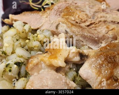 Una foto macro di un pasto placcato con fette di carne arrosto con pelle croccante dorata e morbida polpa bianco-rosato, servita Foto Stock