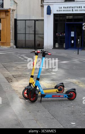 Parigi, Francia - 7 maggio 2022: Due scooter elettrici condivisi parcheggiati in una strada tranquilla vicino alla Bastiglia a Parigi, che illustrano la mobilità urbana moderna Foto Stock