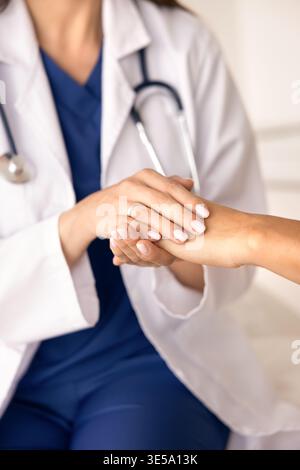 Primo piano medico donna che mette delicatamente il palmo sulla mano del paziente Foto Stock