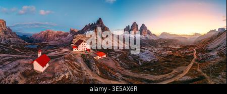 Vista aerea panoramica del tramonto sulle tre Cime di Lavaredo e sul Rifugio Locatelli in autunno nelle Dolomiti Foto Stock