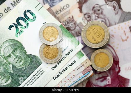 Banconote messicane in peso e monete centavo si accumulano sul tavolo. Monete messicane sulle banconote in valuta MXN da vicino. Concetto di affari, tasse e banche in Messico Foto Stock