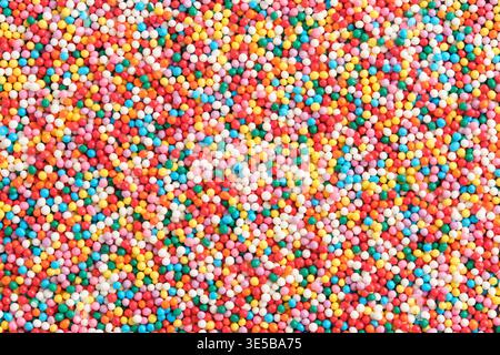 Sfondo ad alta risoluzione migliaia di piccoli zuccheri multicolori non pareils, che creano una texture arcobaleno vivace e caotica Foto Stock