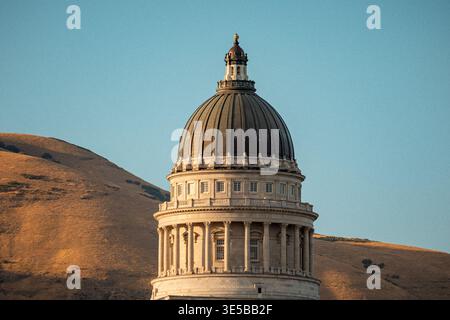 La cupola si affaccia sulla pietra arenaria. Vista panoramica del Campidoglio dello Utah che enfatizza il design classico in un ambiente tranquillo Foto Stock