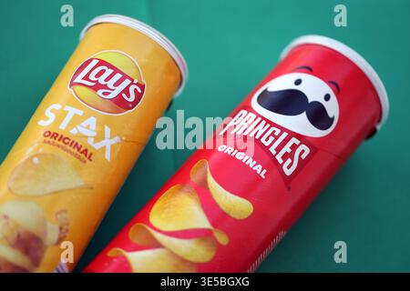KIEV, UCRAINA - 13 MARZO 2026 tubi gialli e rossi con patatine originali Stax e Pringles sul tavolo verde da vicino Foto Stock
