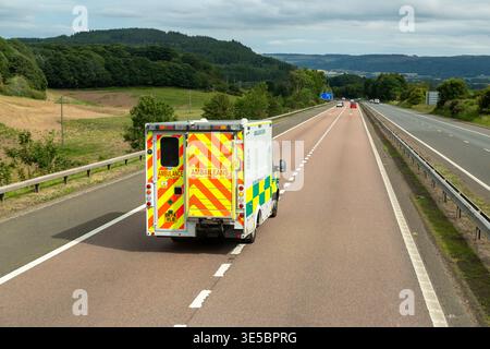 Un'ambulanza di emergenza del servizio di ambulanza scozzese che guida su un'importante strada a doppia carreggiata scozzese Foto Stock