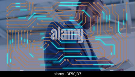 Tenendo un tablet uomo in tuta blu scuro che esegue la scansione in ufficio con occhiali e tracce turchesi, nodi arancioni Foto Stock