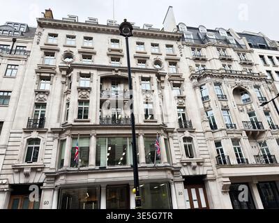 Facciata ornata in pietra di uno storico edificio commerciale nel centro di Londra, Regno Unito, con balconi e bandiere. Foto Stock