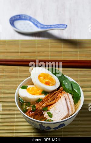 Ramen di maiale giapponese con tagliatelle di grano, funghi Enoki e uovo sodo Foto Stock