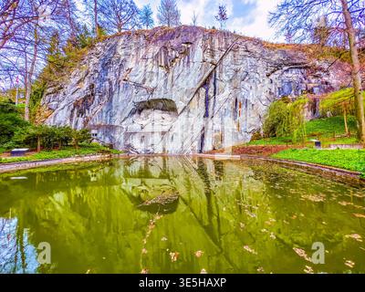 Leone di Lucerna monumento in pietra nella roccia con laghetto commemorativo a Lucerna, Svizzera Foto Stock