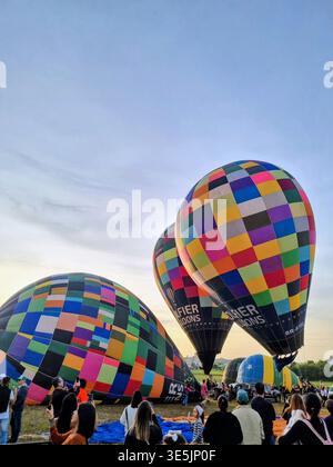 Le colorate mongolfiere che si innalzano all'alba durante un vivace festival, creando una scena magica piena di avventura, viaggi e festeggiamenti. Foto Stock