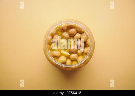 Il vaso contiene le olive in salamoia con aglio e spezie in vista Foto Stock