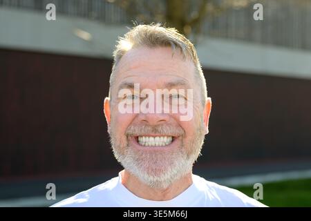 Ritratto ravvicinato di un uomo maturo felice sorridente ampiamente alla luce naturale del sole. Foto Stock