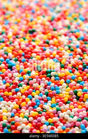Macro verticale piccole sfere di zucchero colorate con campo di profondità basso per uno sfondo dolce astratto Foto Stock