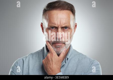 Pensiero, ritratto e uomo d'affari in studio con espressione seria, interrogativa o brainstorming. Risoluzione dei problemi, pianificazione e avvocato maturo con Foto Stock
