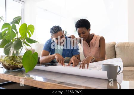 Rivedendo il progetto di diverse coppie appoggiate sul divano nel soggiorno con tavolo e impianto Monstera Foto Stock