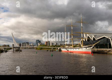 Glenlee è ormeggiata al Museum of Transport sul porto di Glasgow, incorniciata da un moderno ponte pedonale e da un suggestivo cielo nuvoloso. Nave storica, Foto Stock