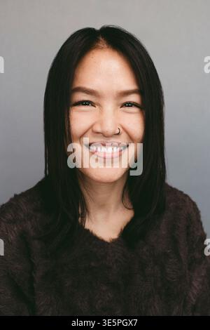 Ritratto di una donna matura sorridente con il naso perforato Foto Stock