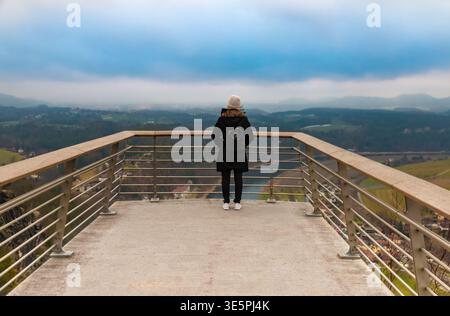 Una donna si erge sulla famosa piattaforma panoramica Basteiaussicht, ammirando la splendida vista panoramica sulla valle dell'Elba in inverno. Foto Stock