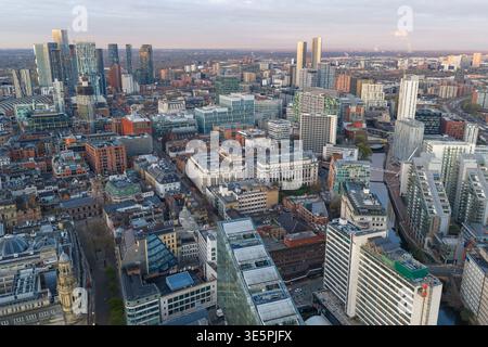 Vista aerea ad alto angolo sul fiume Irwell verso lo skyline centrale di Manchester all'alba. L'architettura moderna e storica si fonde con l'acqua. Foto Stock