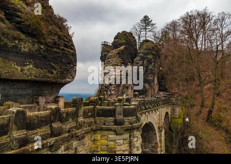 Splendida vista del famoso Ponte Bastei, che si presenta deserta, con il Basteiaussicht sul suo ago di pietra arenaria dove i visitatori si riuniscono, catturati in un... Foto Stock