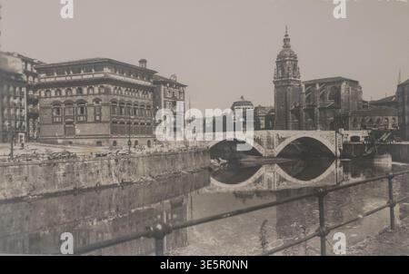 Scansionato da una cartolina d'epoca che mostra Iglesia de San Antón e il ponte di San Antón a Bilbao, Spagna. Segni di usura e segni visibili legati all'età. Nessuna proprietà Foto Stock