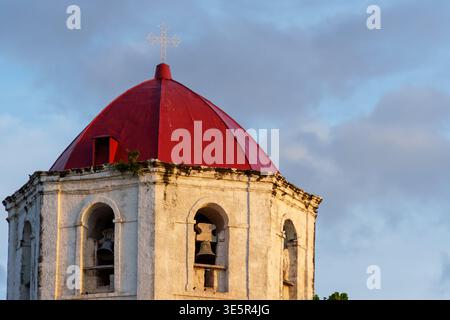 Oslob, Cebu, Filippine - 9 aprile 2025: Una vista ravvicinata mostra il campanile con una cupola rossa. Foto Stock