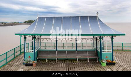 Rifugio vittoriano in legno con panchine sul molo di Clevedon affacciato sull'estuario di Severn nel Somerset, Inghilterra Foto Stock