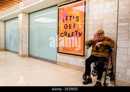 Londra Regno Unito, 02 aprile 2026, un vecchio anziano seduto da solo nel suo Walking Frame Rollator in un centro commerciale vuoto Foto Stock