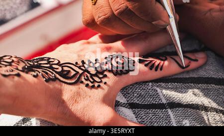 Mano che riceve l'arte dettagliata del corpo all'henné durante il festival dell'India Day a Mosca Foto Stock