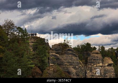 Wandergruppe auf einem Aussichtspunkt der Bastei im Elbsandsteingebirge unter dramatischen Regenwolken, Nationalpark Sächsische Schweiz Foto Stock