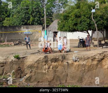 La gente che vive lungo il fiume Magdalena guarda le barche che passano Foto Stock