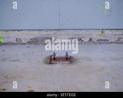 Rete di armature in acciaio arrugginito in un cantiere sabbioso, primo piano di una griglia di rinforzo in ferro per lastre di cemento, fascio di barre di armatura adagiate sulla sommità di un m. Foto Stock
