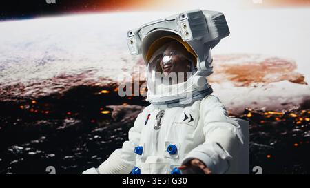 Sorridente membro dell'equipaggio della stazione orbitale deliziato dalla bellezza del pianeta nello spazio. Gioiosa donna afroamericana che guarda con stupore i corpi celesti della galassia durante l'esplorazione planetaria, telecamera A. Foto Stock