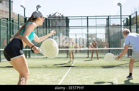 Giovane donna che gioca a Padel Tennis in coppia nel campo da tennis Foto Stock