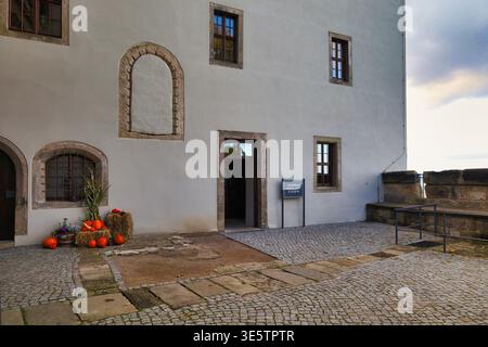 Hof der Magdaleneburg auf Festung Königstein im Herbst, mit Kürbis-Dekoration am Eingang und historischem Pflaster Foto Stock
