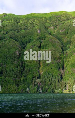 Vista sul lago del cratere vulcanico. Caldera di Sete Cidades sull'isola di Sao Miguel. Lussureggianti scogliere verdi circondano acque blu profonde. Paesaggio naturale dell'arcipelago delle Azzorre Foto Stock