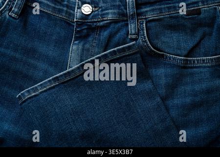 Tasche e orlo dei jeans in denim che mostrano cuciture e texture del tessuto Foto Stock