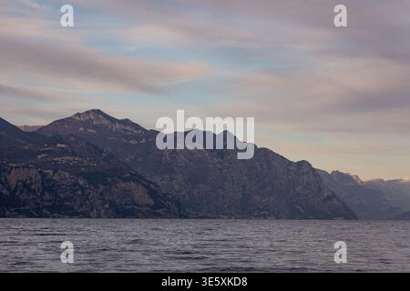 Paesaggio montano sul Lago di Garda al tramonto con acque calme, Italia Foto Stock