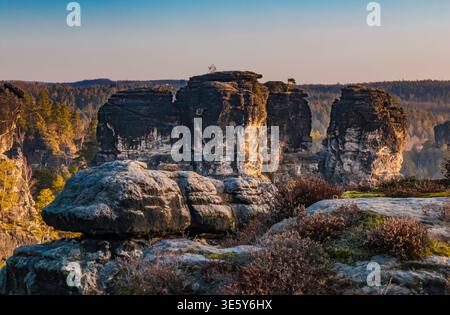 Splendida vista delle torreggianti formazioni rocciose di Bastei che si innalzano sopra il Parco Nazionale della Svizzera sassone in gennaio durante l'alba. Il maggiore... Foto Stock